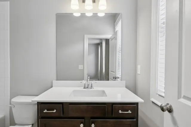 a bathroom with a sink a toilet and a mirror