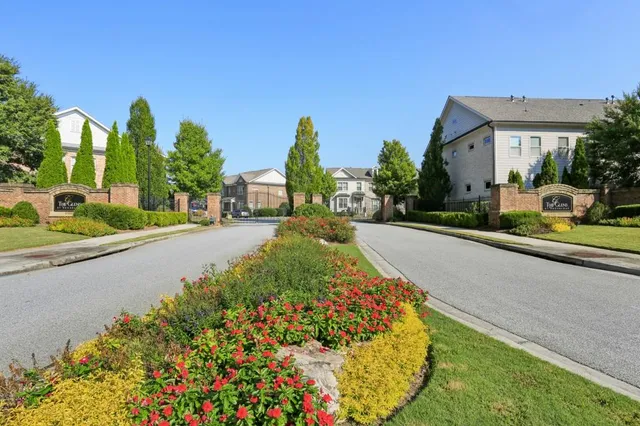 a view of a garden with a lot of flower plants and wooden fence