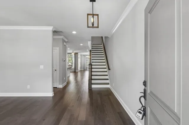 a view of a hallway with wooden floor and stairs