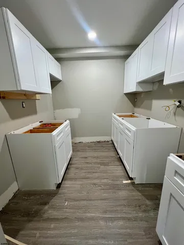 a utility room with wooden floor washer and dryer
