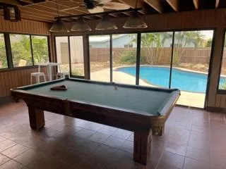 a bedroom with a bed a chair and a potted plant on the table