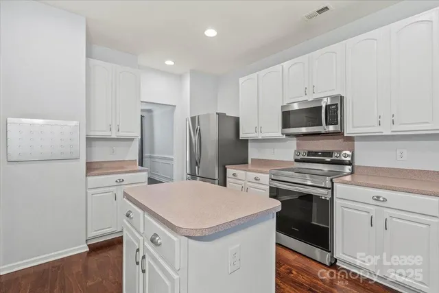 a kitchen with stainless steel appliances a refrigerator stove and microwave