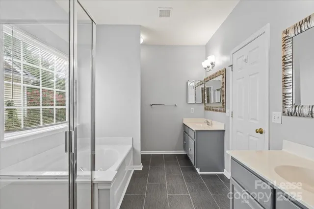 a bathroom with a tub sink and mirror