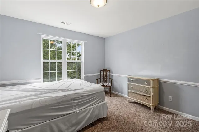 a bedroom with a bed dresser and a window