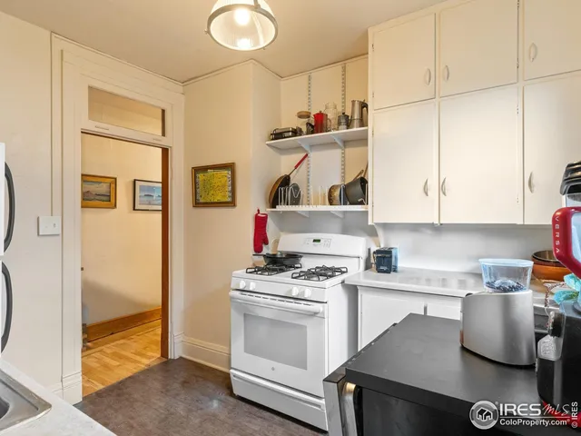 a kitchen with white cabinets and appliances