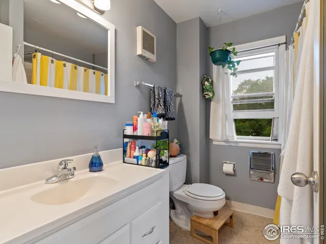 a bathroom with a sink vanity mirror and toilet