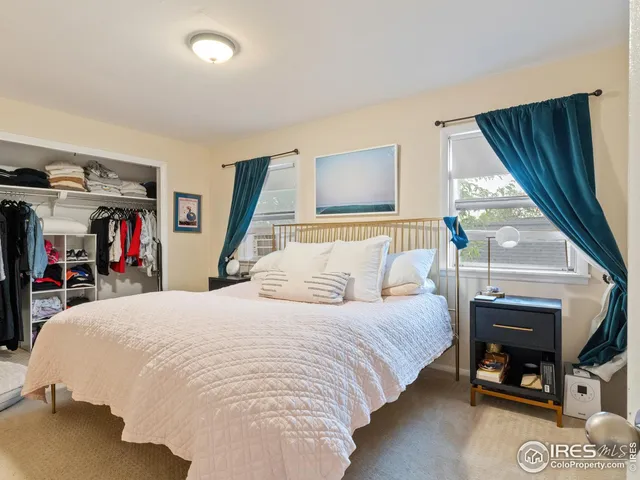a bedroom with a bed and a dresser with wooden floor