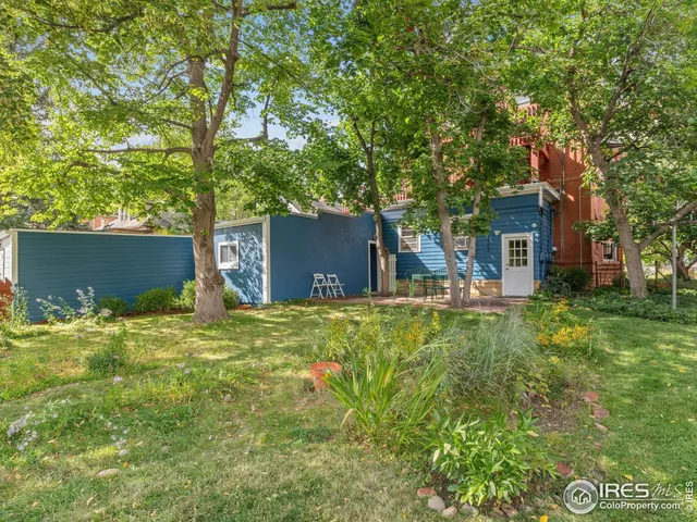 a backyard of a house with table and chairs