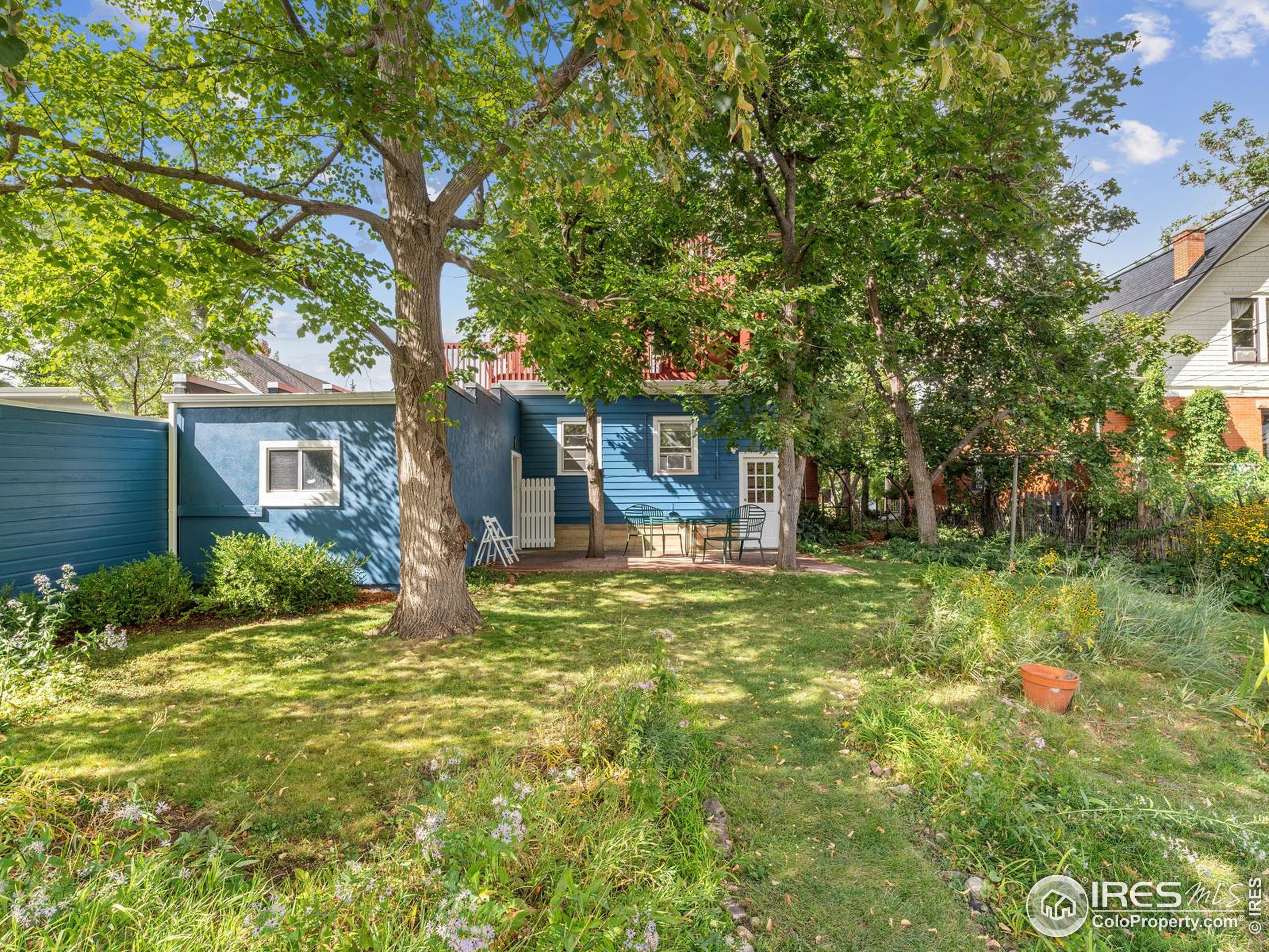 1828 Pine Street Boulder, CO 80302 - Photo 43 of 50 a backyard of a house with table and chairs under an umbrella