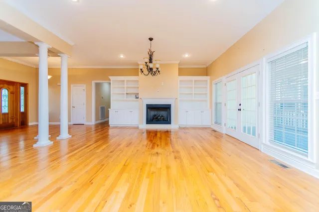 a large white kitchen with wooden floor and a sink