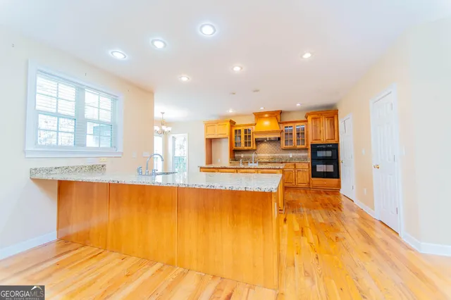 a large kitchen with stainless steel appliances granite countertop a sink and cabinets