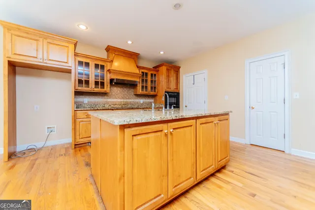 a large kitchen with stainless steel appliances granite countertop a large counter top a sink a window and a counter top space