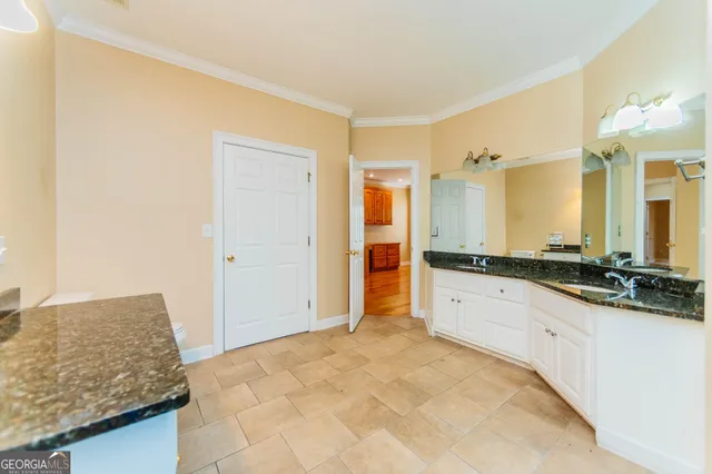 a bathroom with a granite countertop sink mirror vanity and bathtub