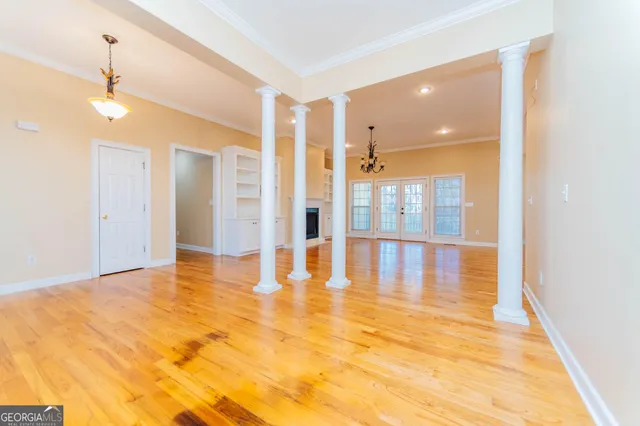 a view of empty room with wooden floor and fireplace