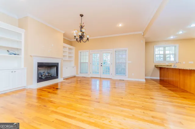 a view of a big room with wooden floor and windows