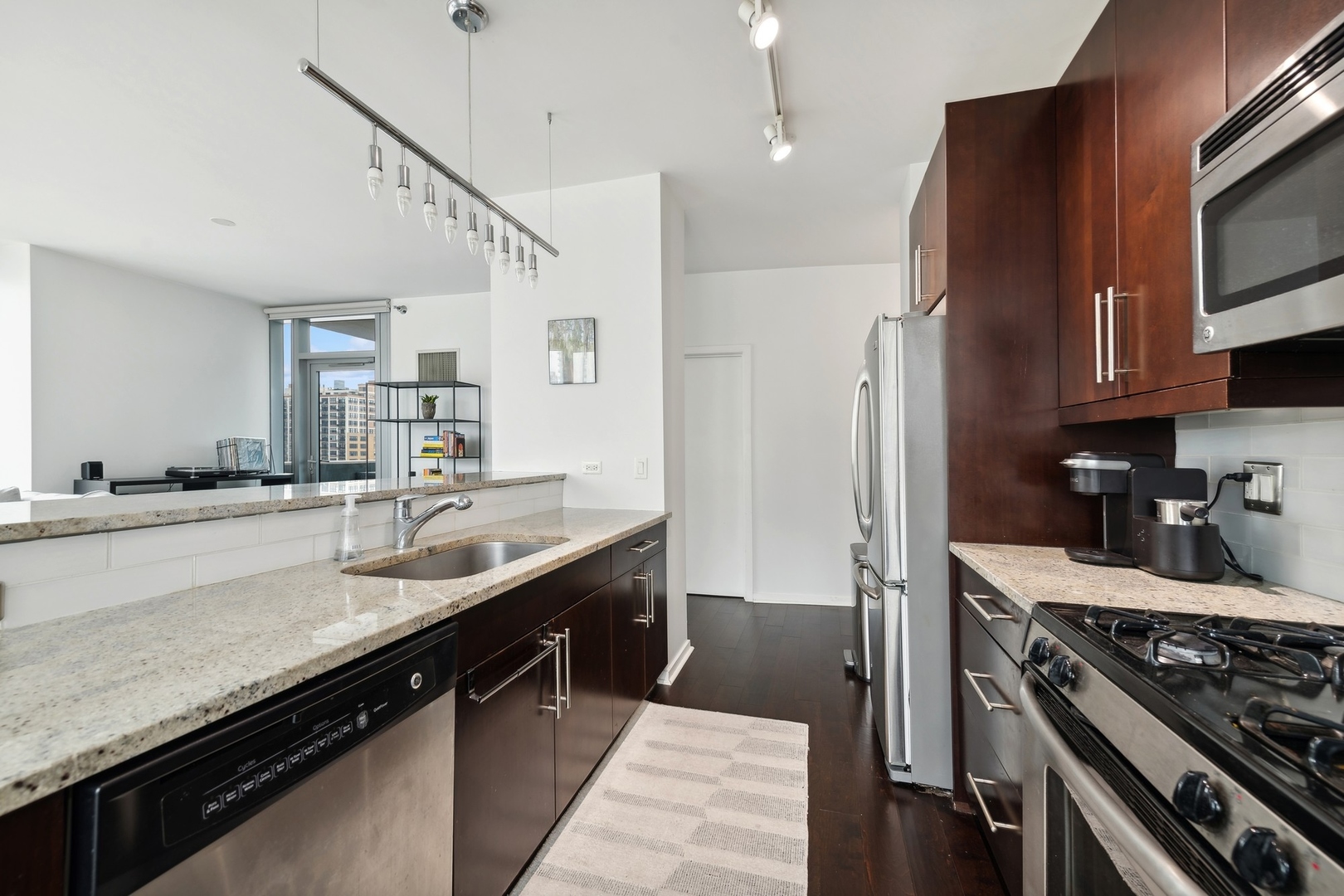 123 South Green Street, Unit 703B Chicago, IL 60607 - Photo 3 of 7 a kitchen with stainless steel appliances granite countertop a sink stove and refrigerator