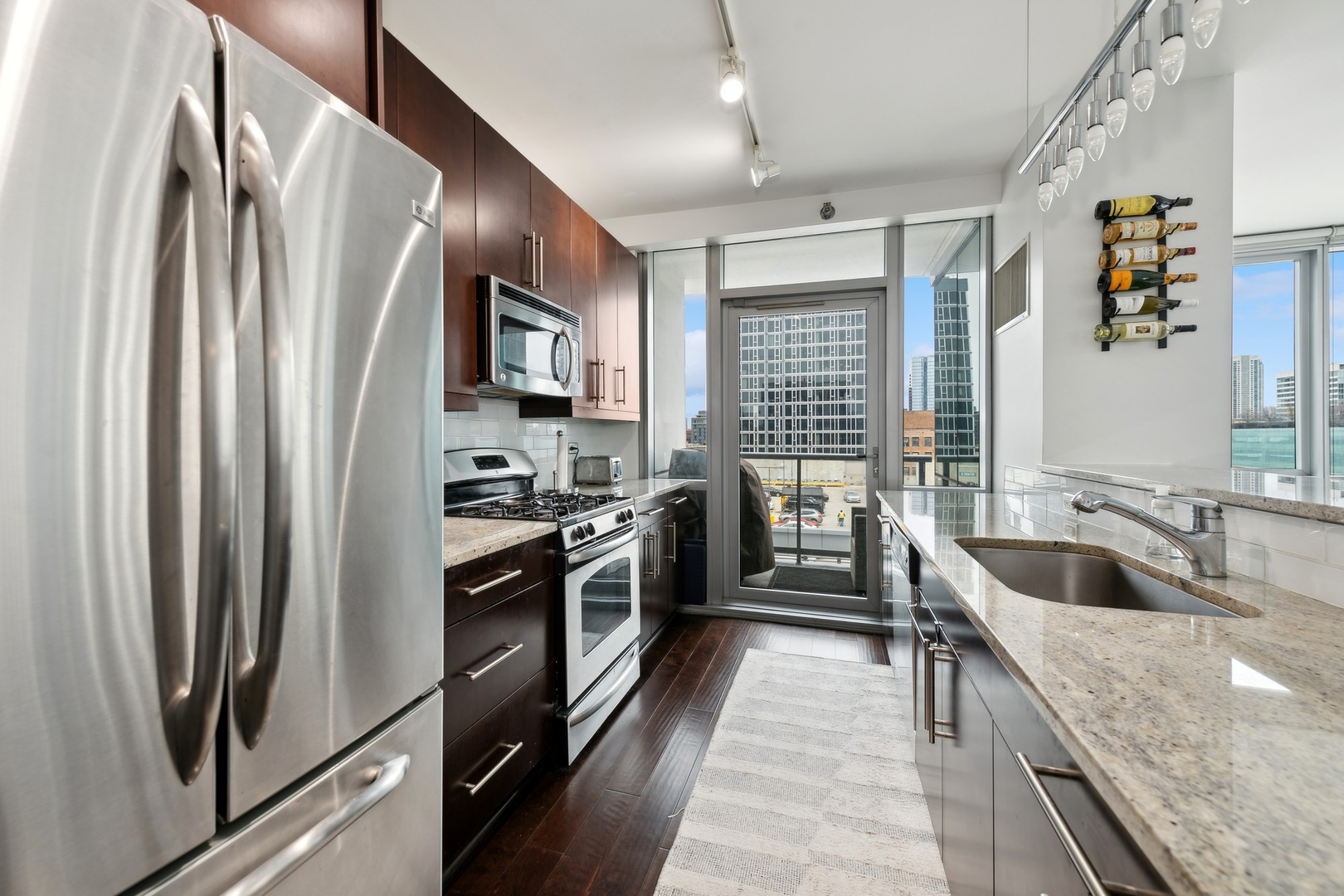 123 South Green Street, Unit 703B Chicago, IL 60607 - Photo 4 of 7 a kitchen with stainless steel appliances granite countertop a refrigerator stove and sink