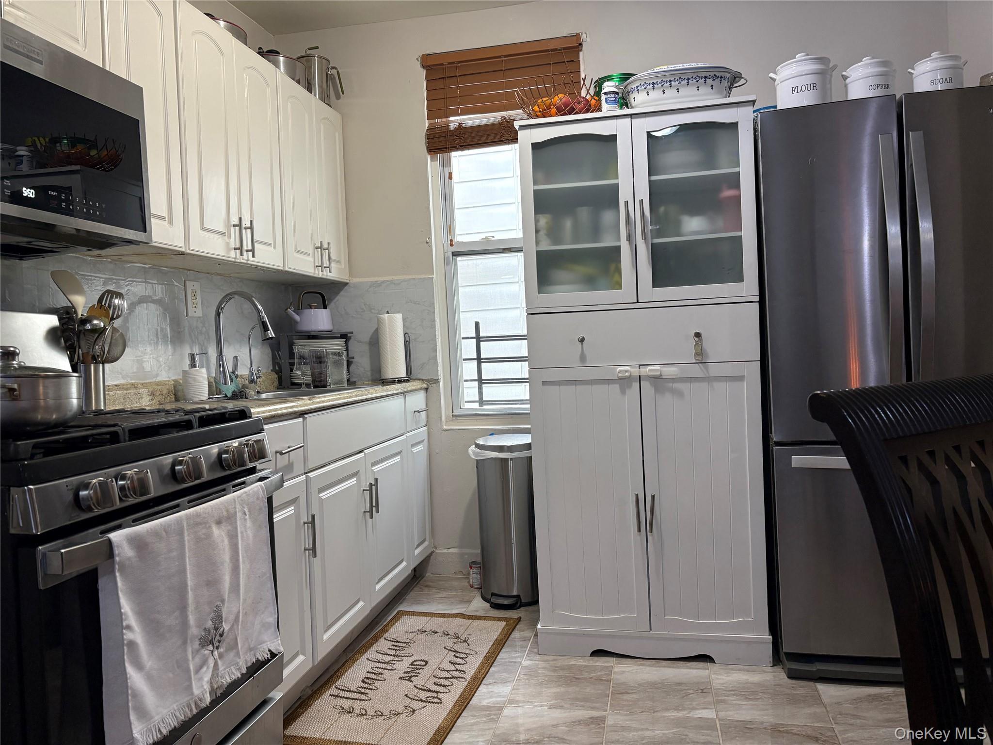 97-33 89th Street Queens, NY 11416 - Photo 4 of 13 a kitchen with stainless steel appliances granite countertop a refrigerator a stove and a sink