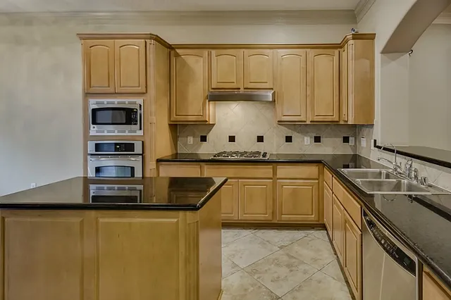 a kitchen with stainless steel appliances a sink stove and refrigerator