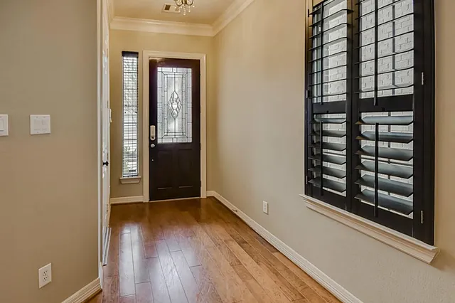 a view of a hallway with wooden floor and a window