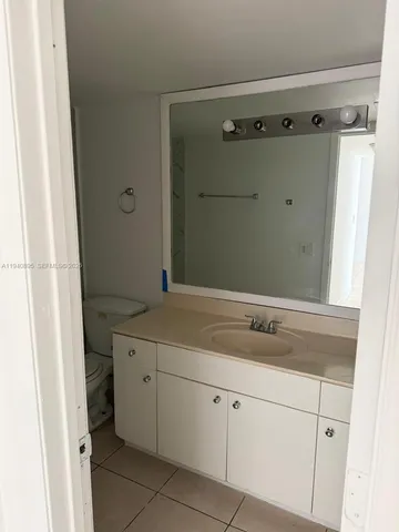 a bathroom with a granite countertop sink and mirror