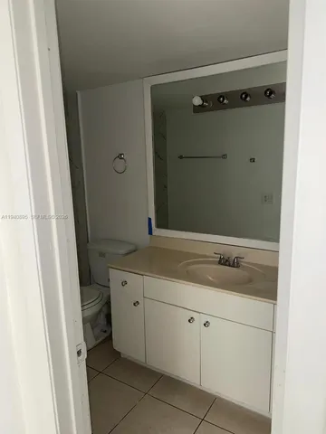 a bathroom with a granite countertop sink a mirror and shower