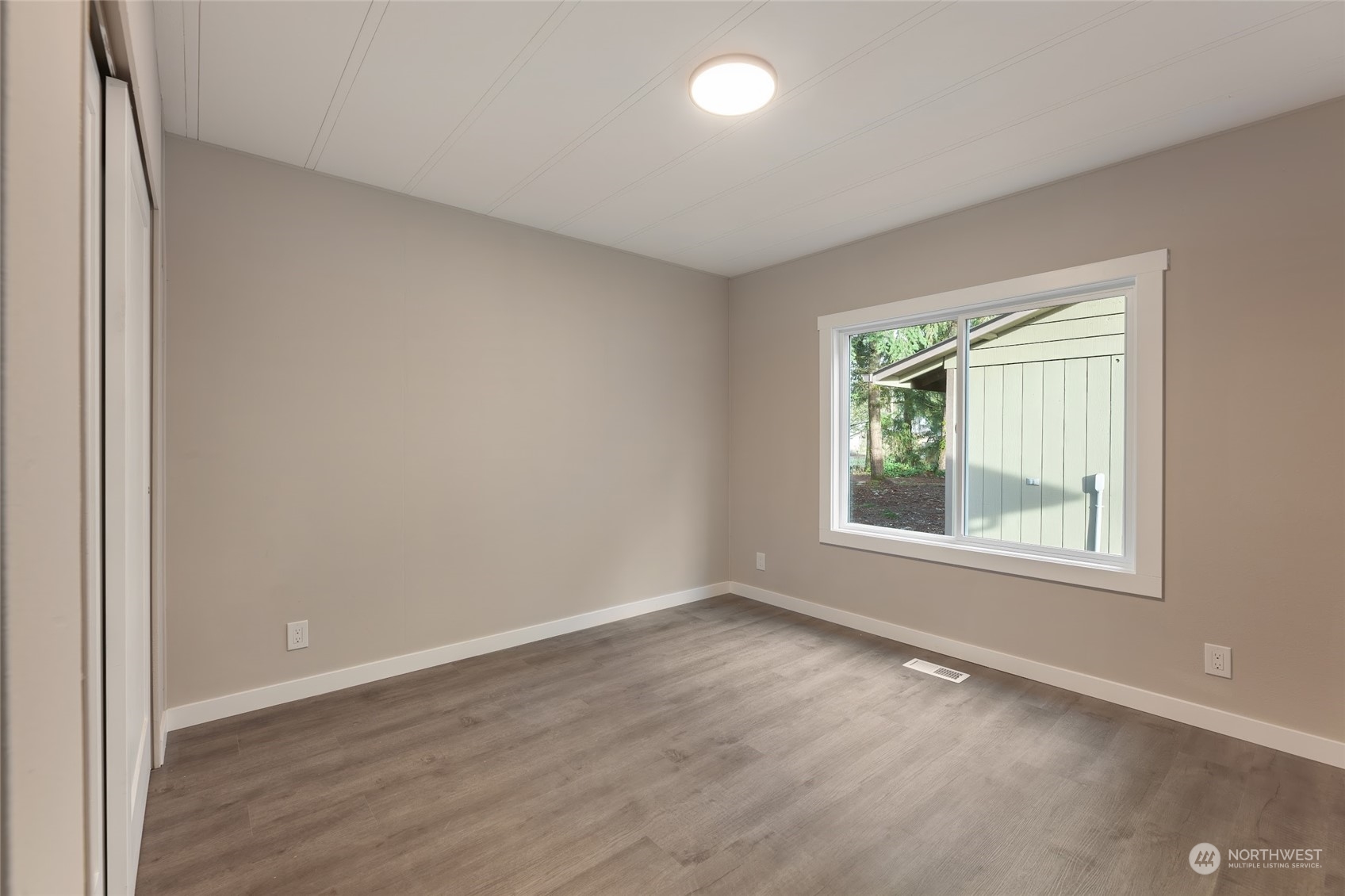 7020 187th Avenue Southwest Rochester, WA 98579 - Photo 15 of 40 an empty room with wooden floor and windows