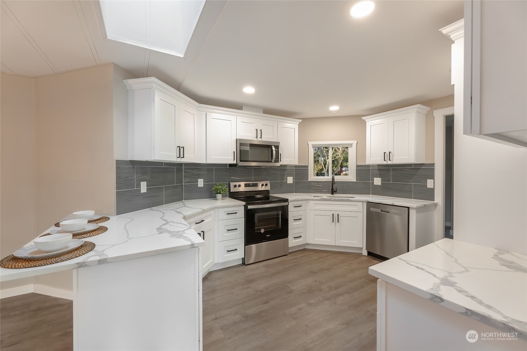7020 187th Avenue Southwest Rochester, WA 98579 - Photo 24 of 40 a kitchen with granite countertop a sink stainless steel appliances and white cabinets