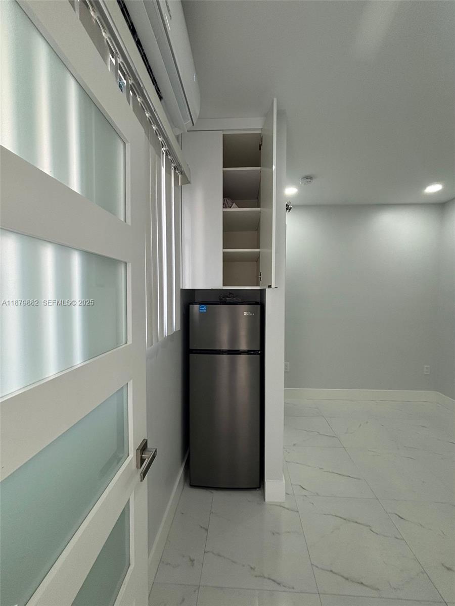29303 Southwest 142nd Avenue Homestead, FL 33033 - Photo 3 of 7 a view of a refrigerator in kitchen and an empty room