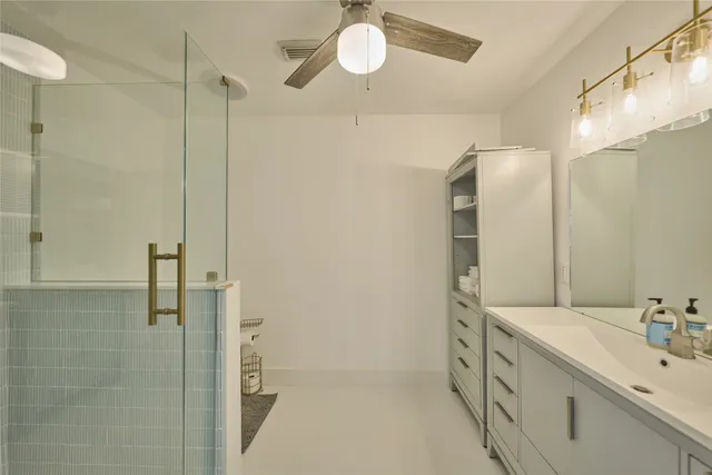 a bathroom with a double vanity sink a toilet and shower