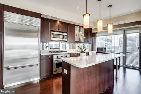 a kitchen with stainless steel appliances granite countertop a sink a stove and a refrigerator