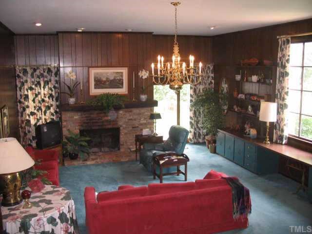 3046 Farrior Road Raleigh, NC 27607 - Photo 5 of 10 a living room with furniture a chandelier and a fireplace