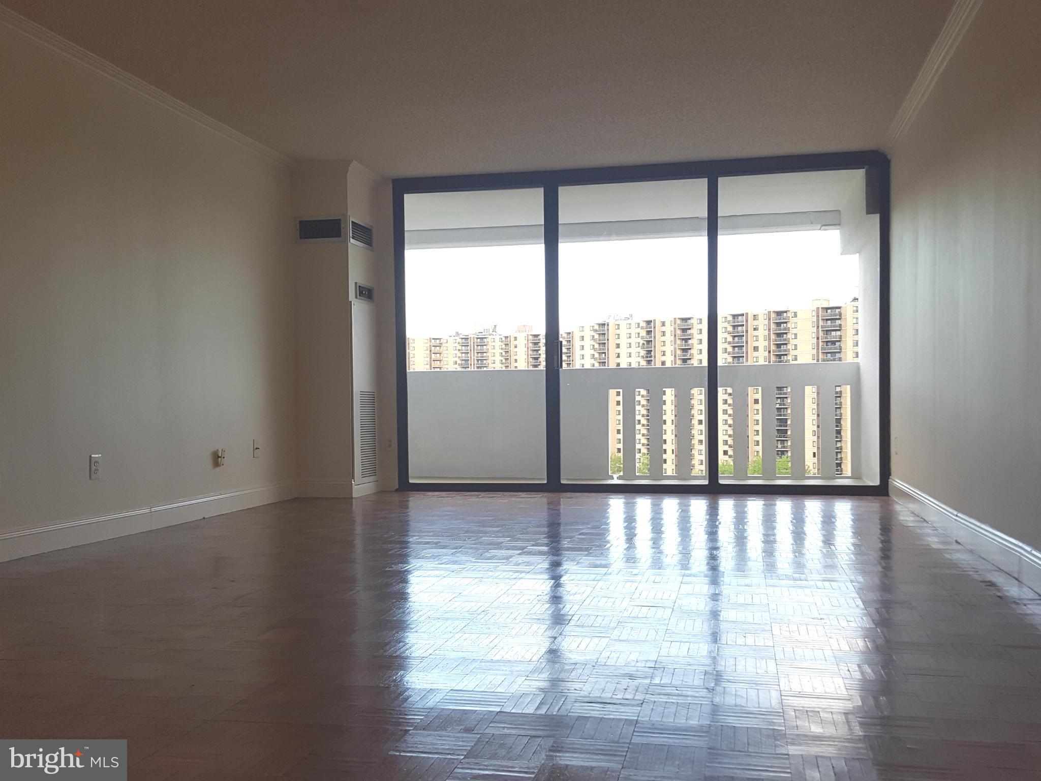 6101 Edsall Road, Unit 1506 Alexandria, VA 22304 - Photo 12 of 26 a view of an empty room with wooden floor and a window
