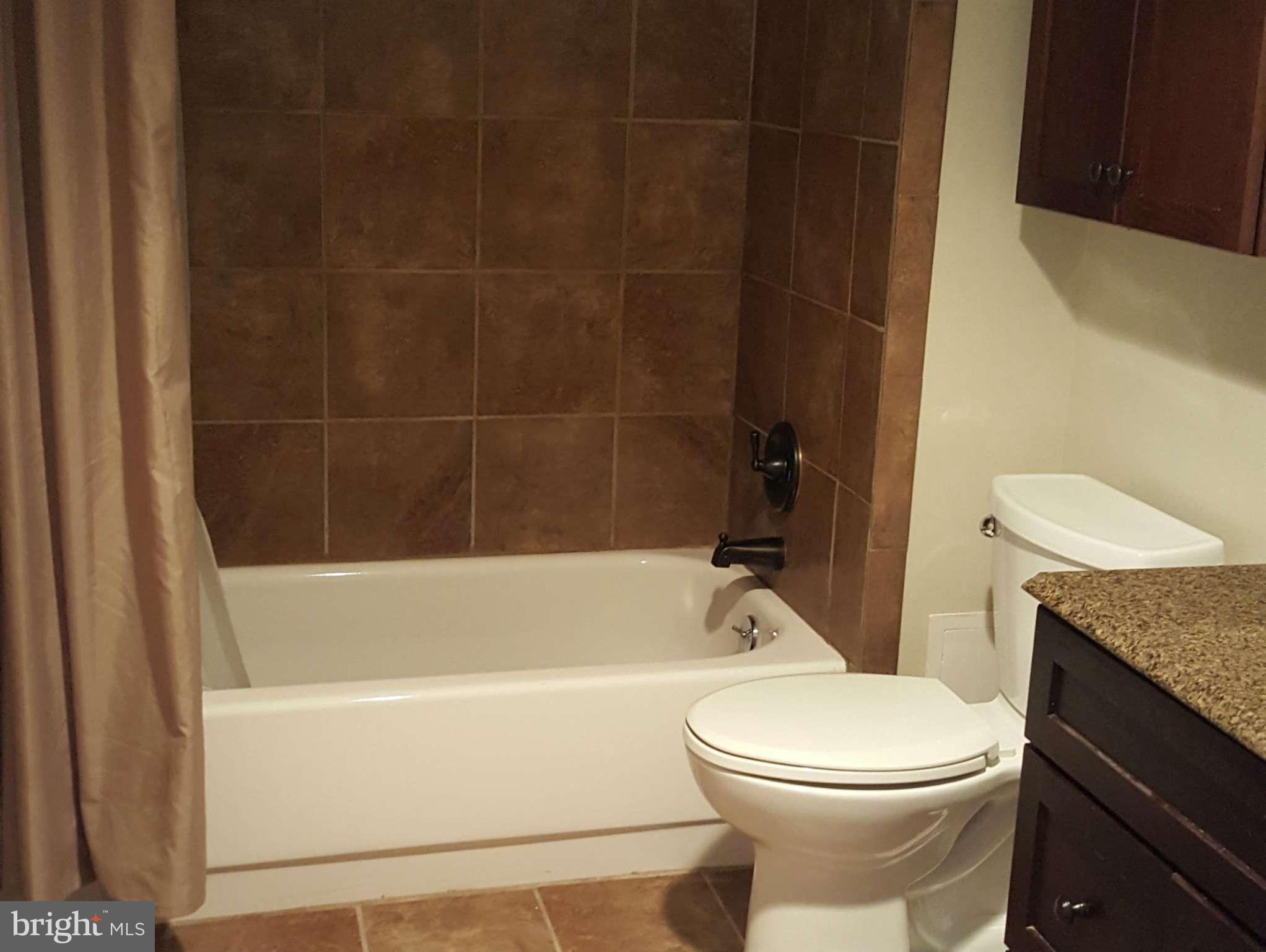 6101 Edsall Road, Unit 1506 Alexandria, VA 22304 - Photo 19 of 26 a bathroom with a granite countertop toilet a sink and bathtub