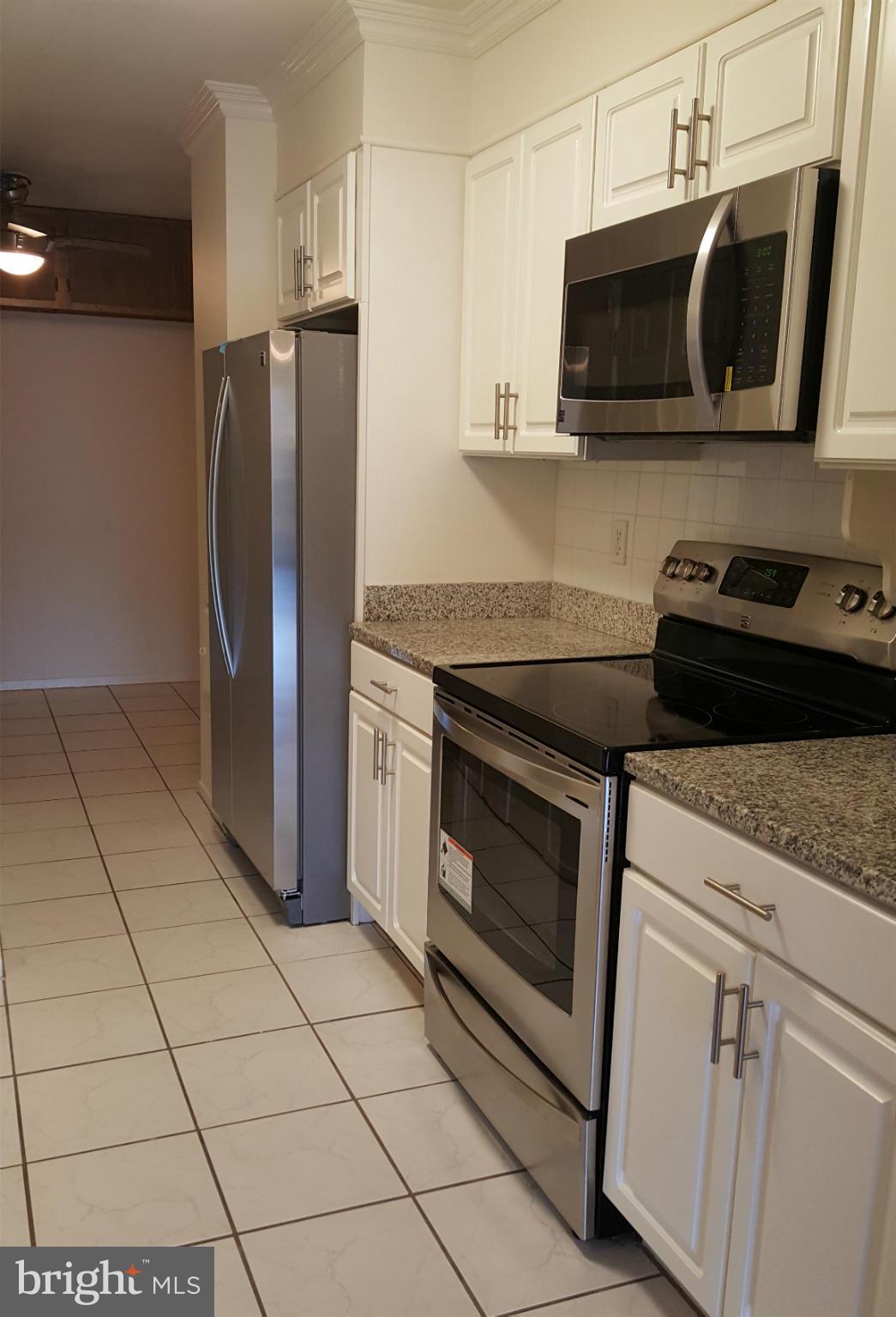 6101 Edsall Road, Unit 1506 Alexandria, VA 22304 - Photo 3 of 26 a kitchen with stainless steel appliances granite countertop a stove microwave and refrigerator