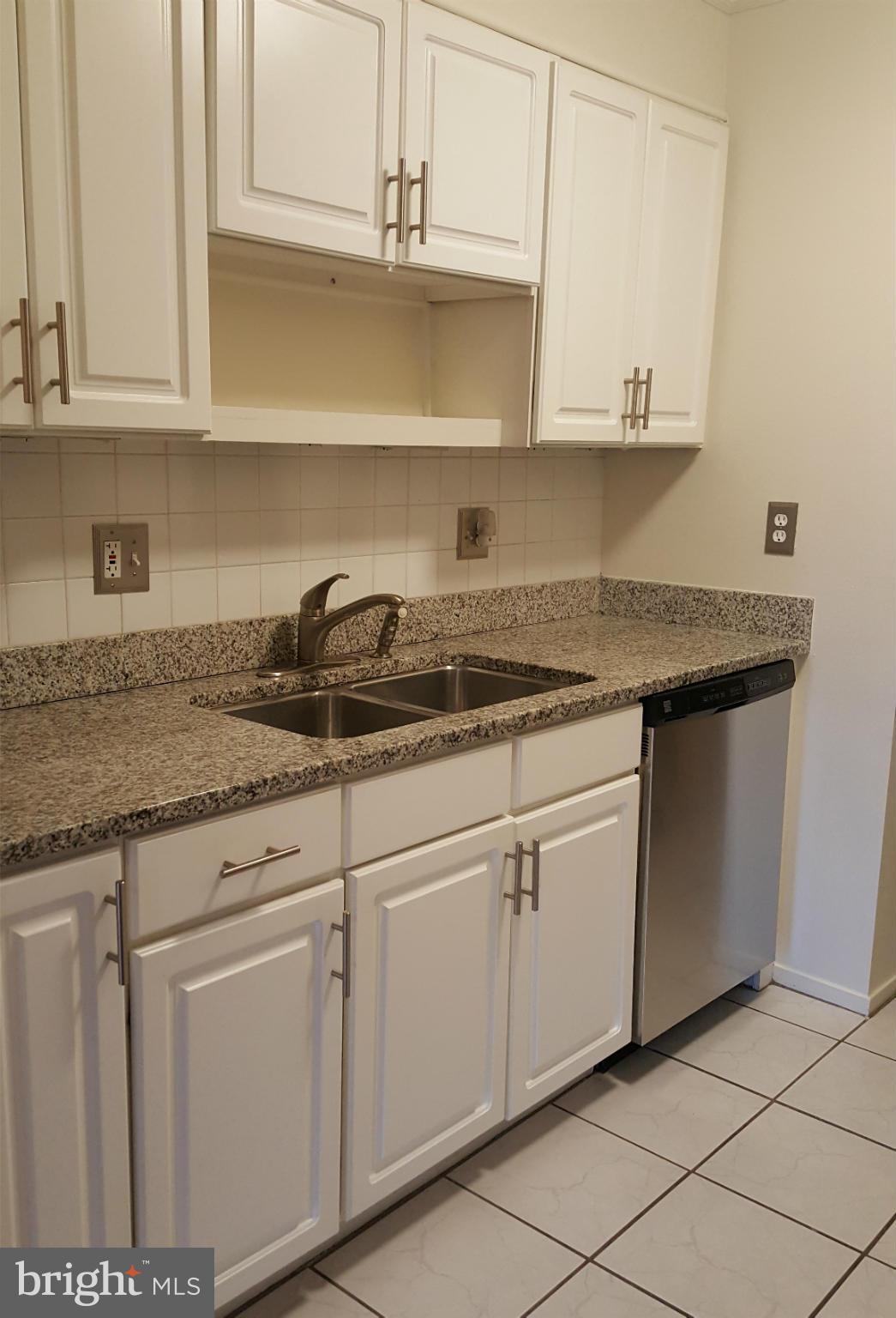 6101 Edsall Road, Unit 1506 Alexandria, VA 22304 - Photo 4 of 26 a kitchen with granite countertop white cabinets and a sink