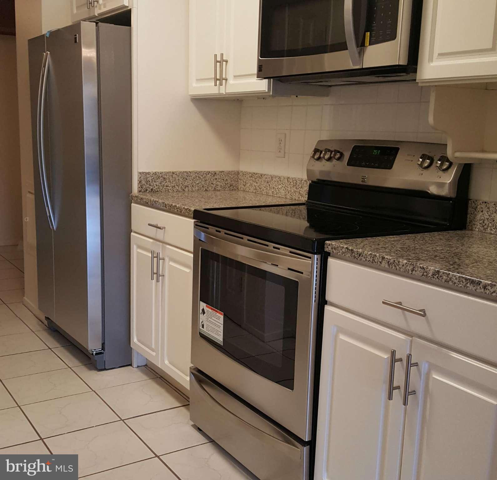 6101 Edsall Road, Unit 1506 Alexandria, VA 22304 - Photo 5 of 26 a kitchen with granite countertop white cabinets and stainless steel appliances