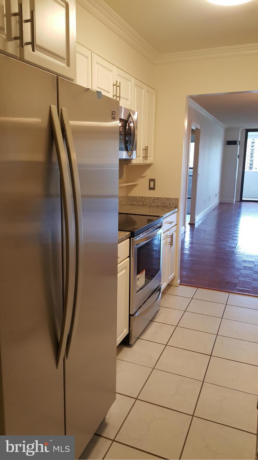 6101 Edsall Road, Unit 1506 Alexandria, VA 22304 - Photo 8 of 26 a kitchen with granite countertop a refrigerator and a stove