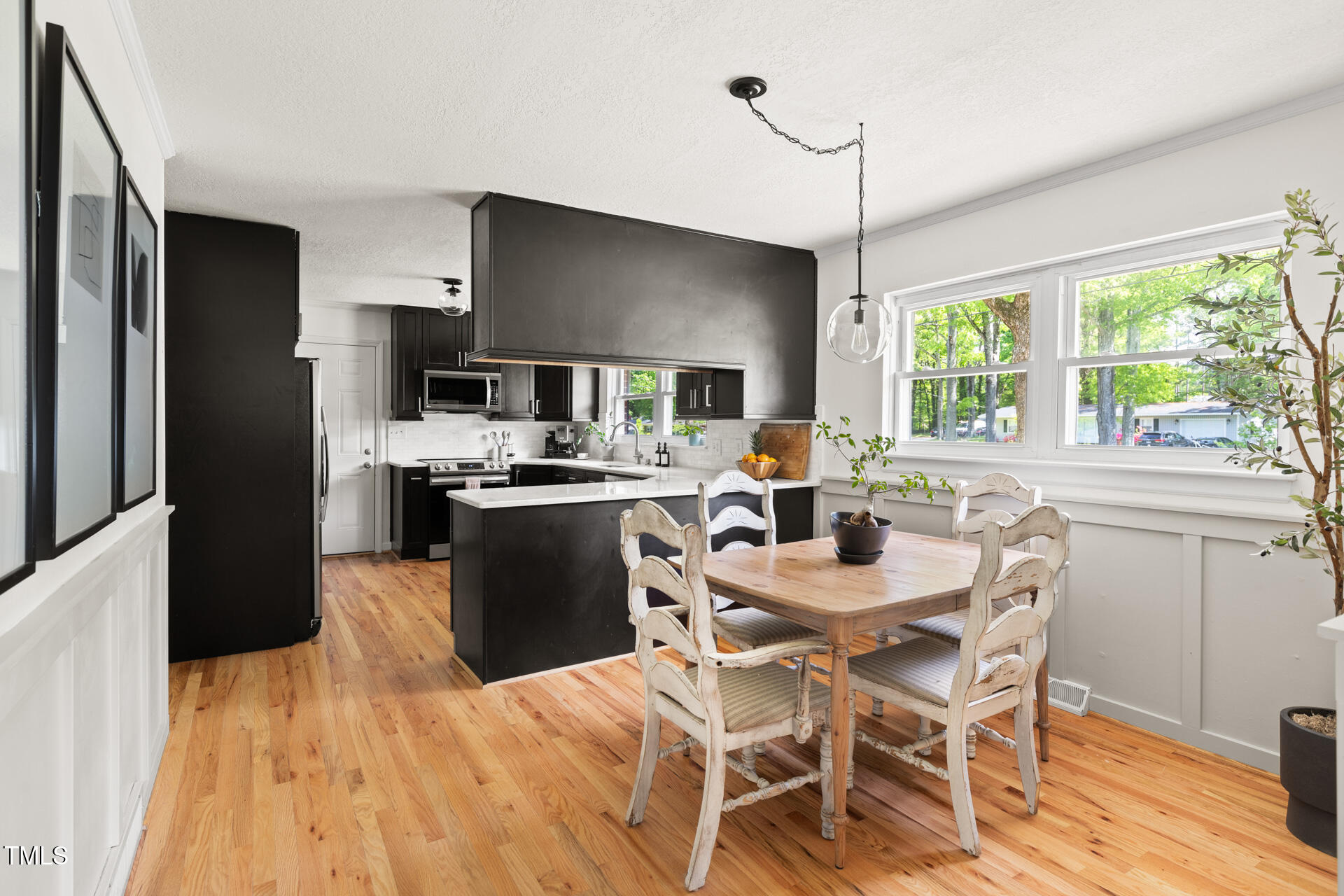2702 Richwood Road Durham, NC 27705 - Photo 19 of 47 a kitchen with a table chairs refrigerator and microwave