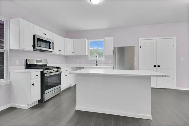 a kitchen with stainless steel appliances white cabinets and a sink