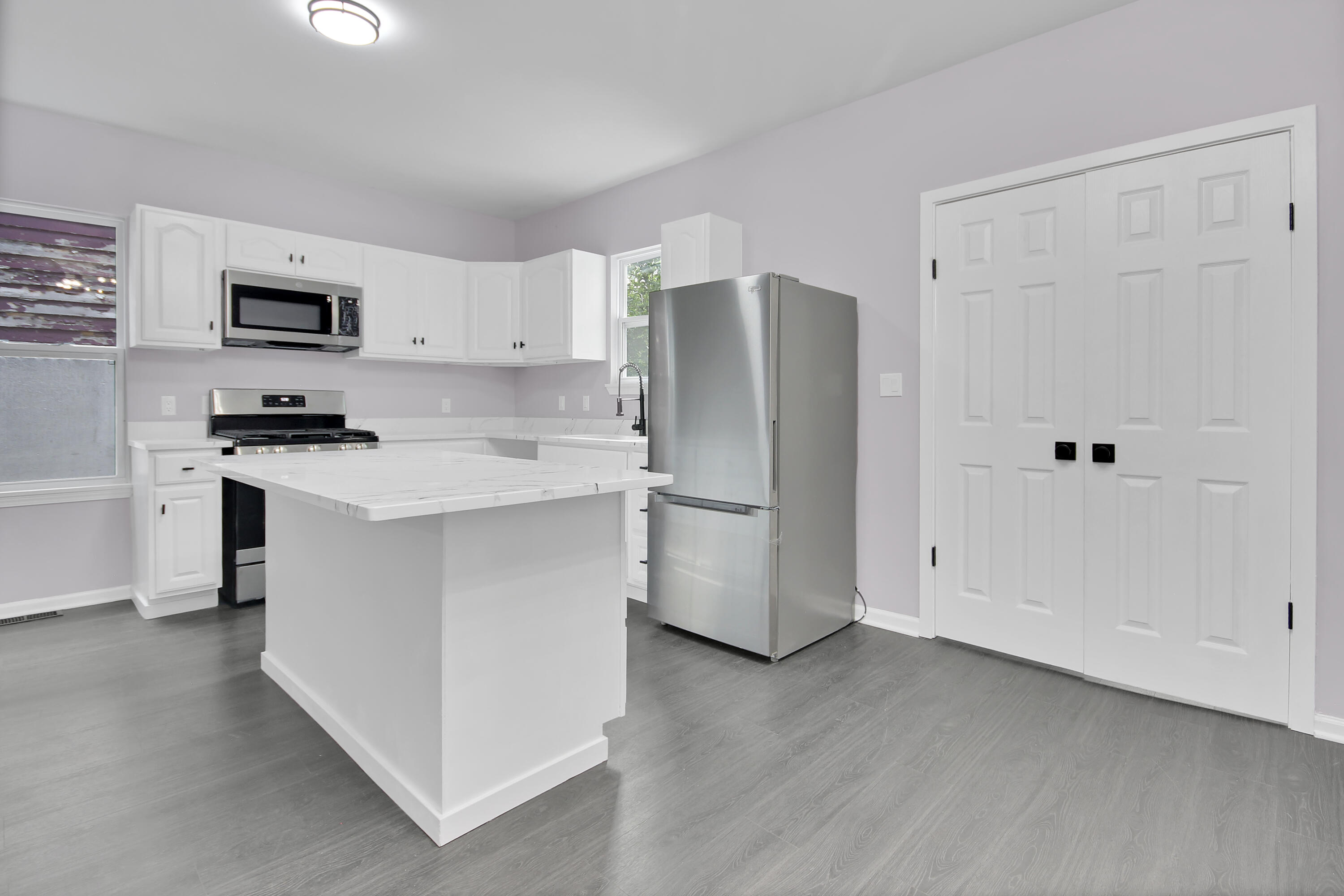 836 Fayette Street Gary, IN 46403 - Photo 4 of 16 a kitchen with stainless steel appliances a refrigerator sink and white cabinets
