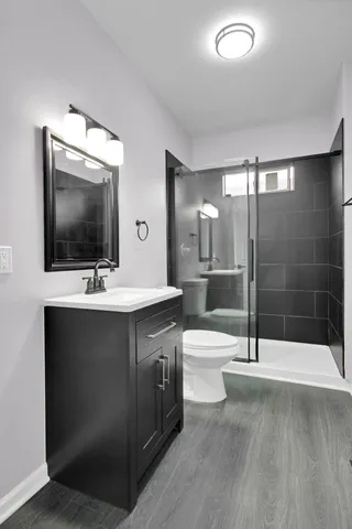 a bathroom with a sink a toilet and shower