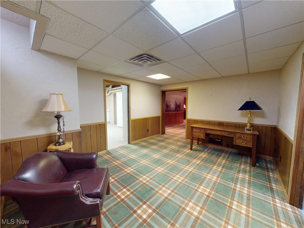 9870 Hobart Road Willoughby, OH 44094 - Photo 36 of 50 Living area featuring a wainscoted wall, carpet, wood walls, and a paneled ceiling