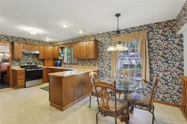 a kitchen with kitchen island a counter top space a sink stainless steel appliances and cabinets