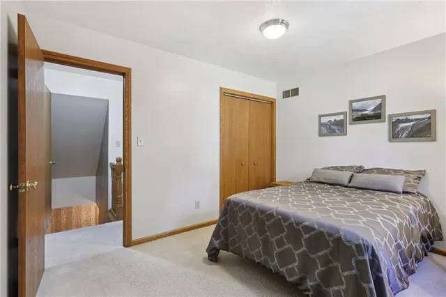 a bedroom with a bed and painting on the wall