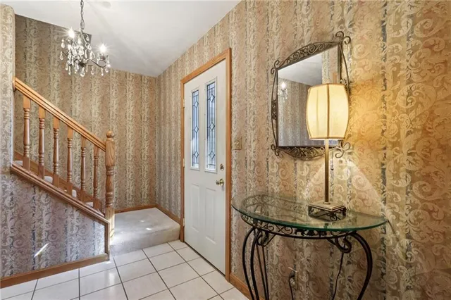 a view of a hallway with chandelier and entryway