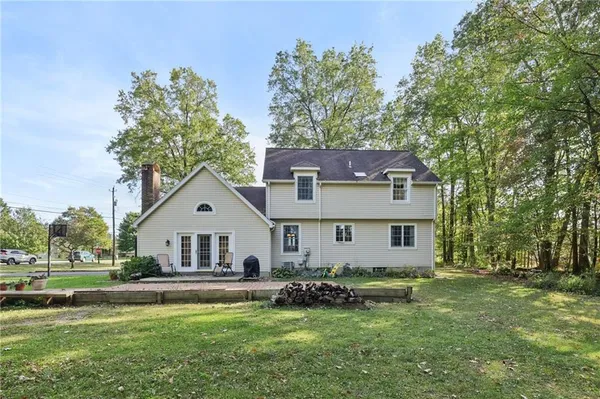 a front view of a house with a garden and trees