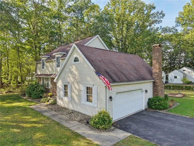 a aerial view of a house next to a yard with big trees