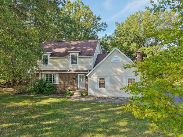 a front view of a house with a garden and plants