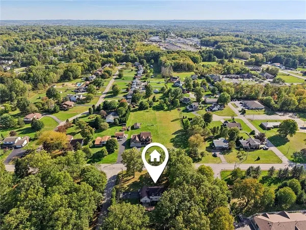 an aerial view of a residential houses with outdoor space and parking